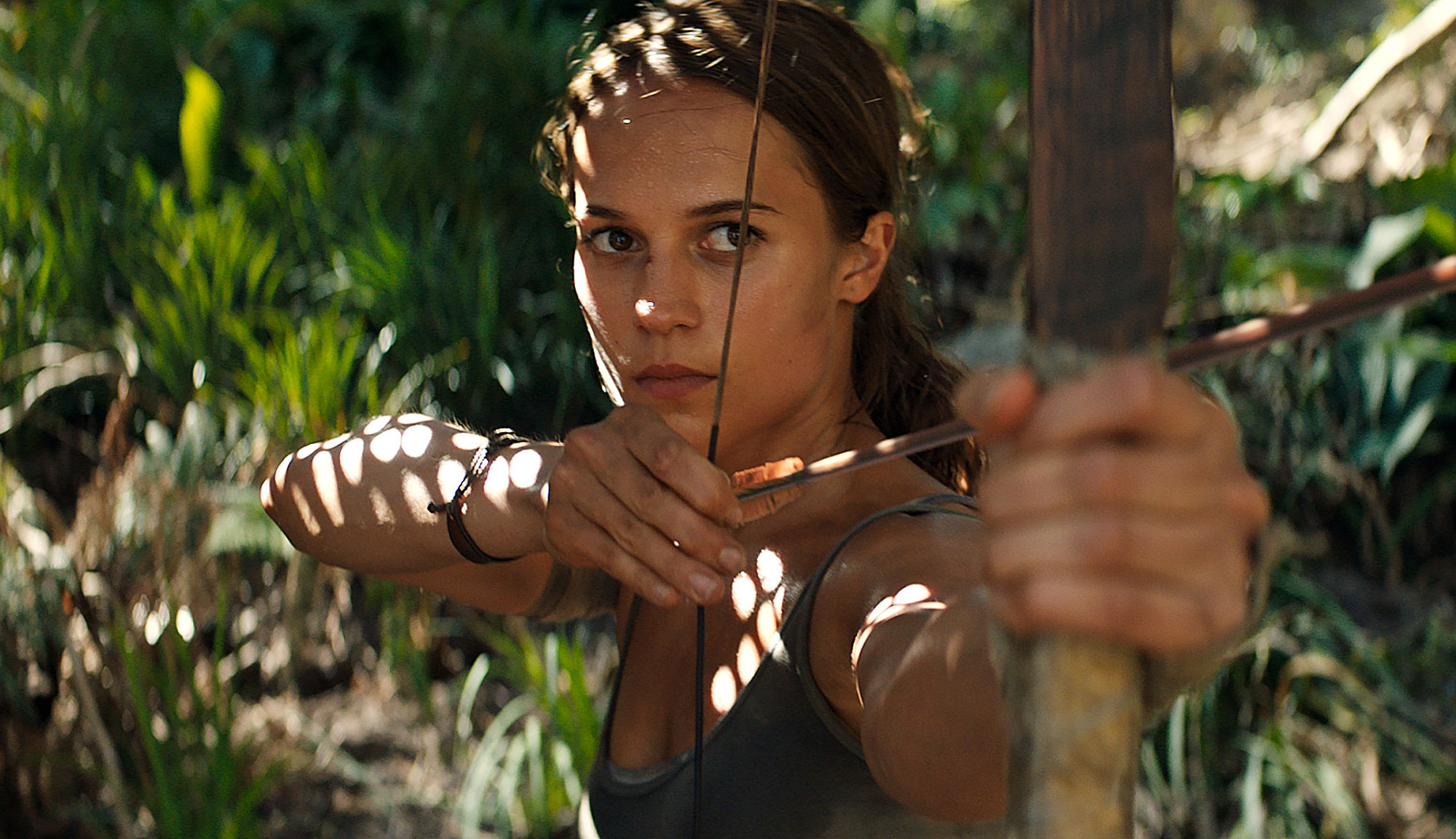 Alicia Vikander holding bow and arrow in Tomb Raider