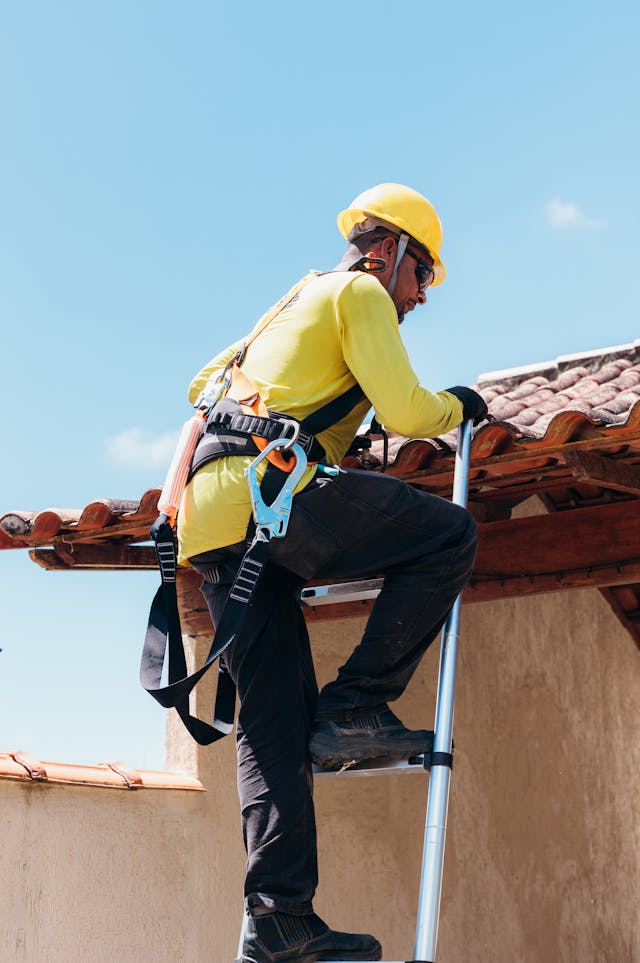 worker climbing onto roof
