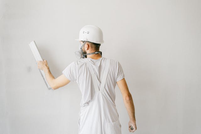 man in white work clothes working in room