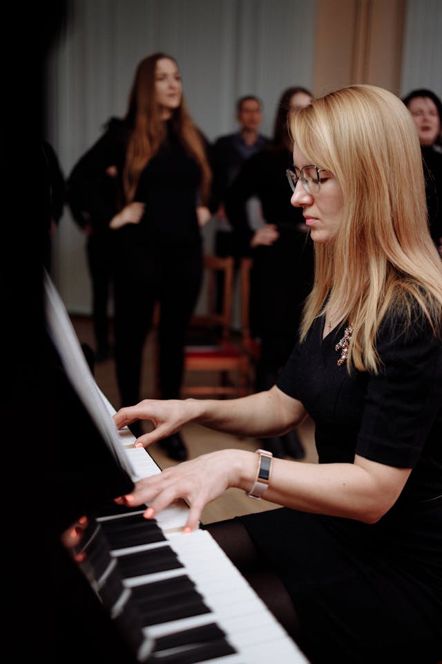 blonde woman playing piano in black dress