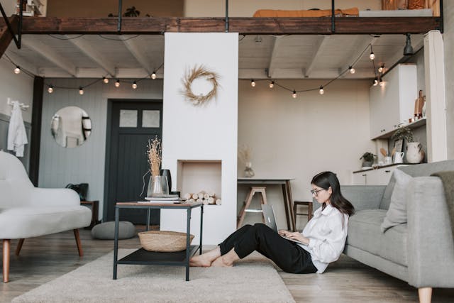 attractive woman side view sitting on floor of living room with laptop
