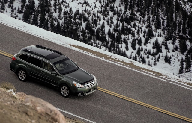 car on road near snowy mountains