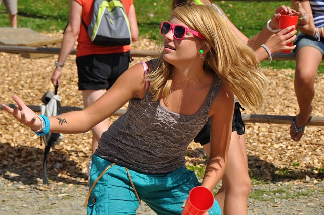 pretty blonde woman playing sport outside in tank top and blue pants