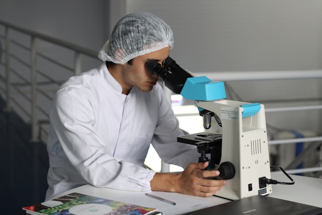 researcher in a lab looking into microscope