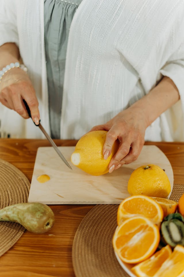 womn cutting oranges on wood cutting board