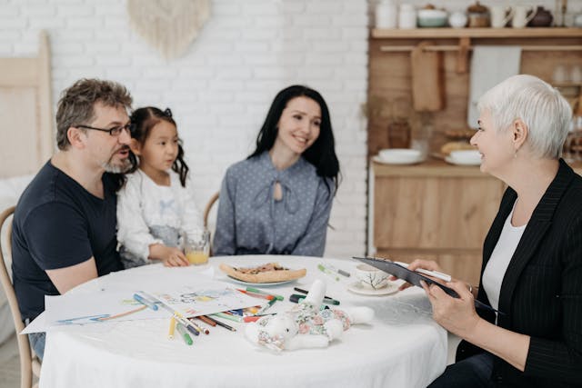 man woman and child around table with social worker