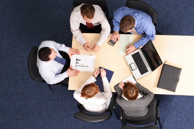 ariel view of people sitting at desk at work with laptop