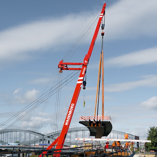 red crane lifting a boat