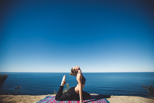woman doing yoga in black yoga pants near water