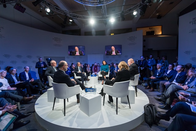 people around table on stage at a conference