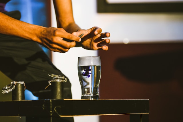 glass on table with man's hands over it