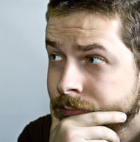 closeup of man with beard with hand on his chin