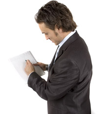 man in suit jacket writing on a pad