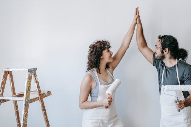 man and woman high five celbrating finishing painting project