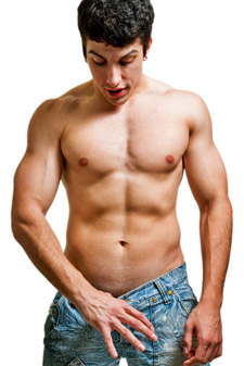 young man with muscles and no shirt tugging at his jeans and looking down