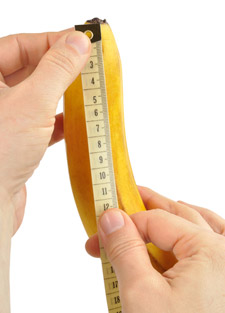 two hands holding tape measure against a banana