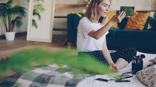 pretty woman sitting on bed applying makeup