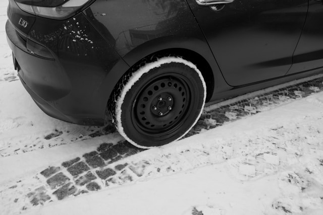 closeup of car tore on black car on snowy road