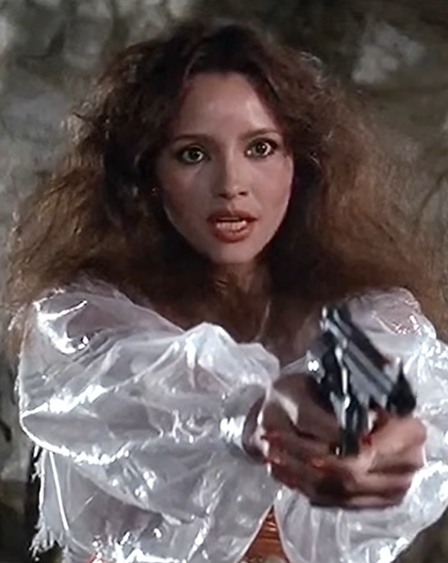 Barbara Carrera as Fatima Blush holding gun