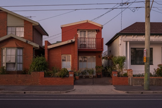 small house on street with electricity pole and lines