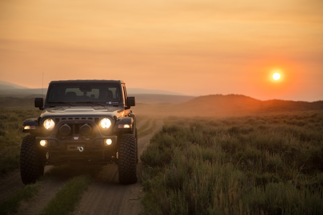 jeep front view with lights on at sunset