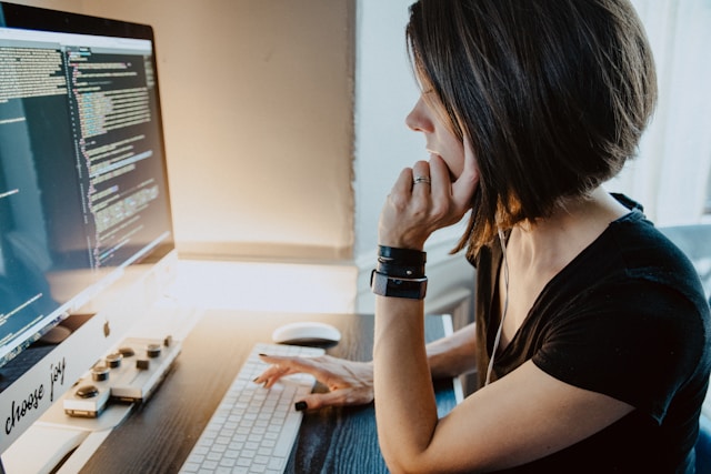 side view of attractive woman using desktop comuter at desk