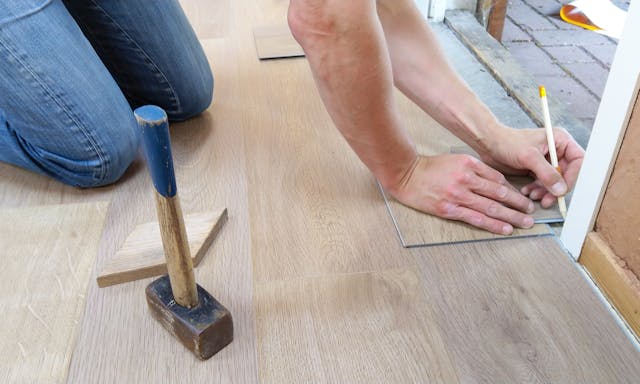 person kneeling on floor writing with pencil