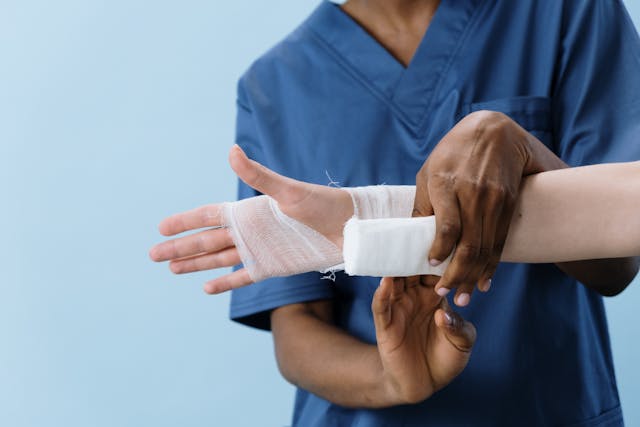 closeup of bandage being put on hand by nurse