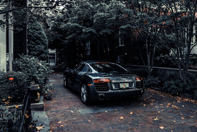 rear view of Audi car parked in driveway with trees