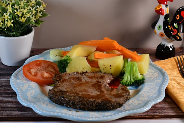 plate of food with steak and steamed vegetables
