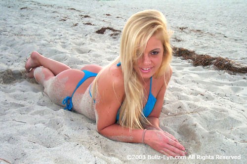 Murphy in blue thong bikini laying on beach
