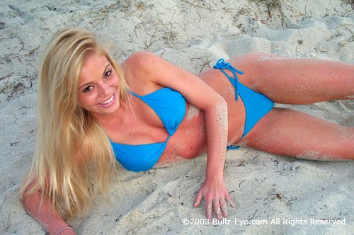Murphy in blue thong bikini laying on beach