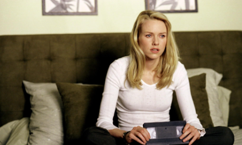 The Ring - Naomi Watts sitting on couch holding video casette tape