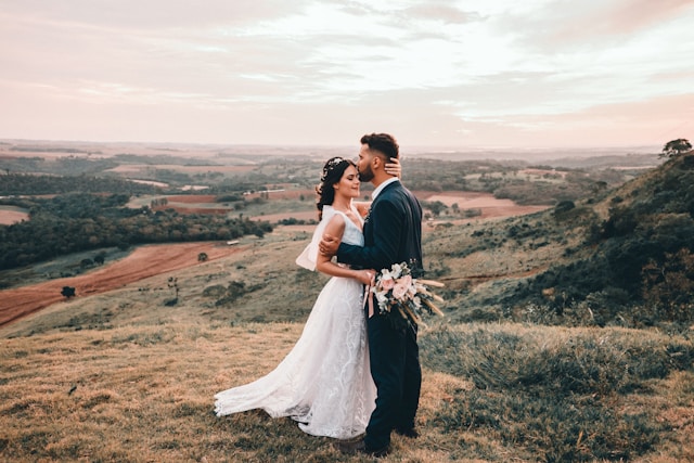 bride and groom embracing outdoors in a field