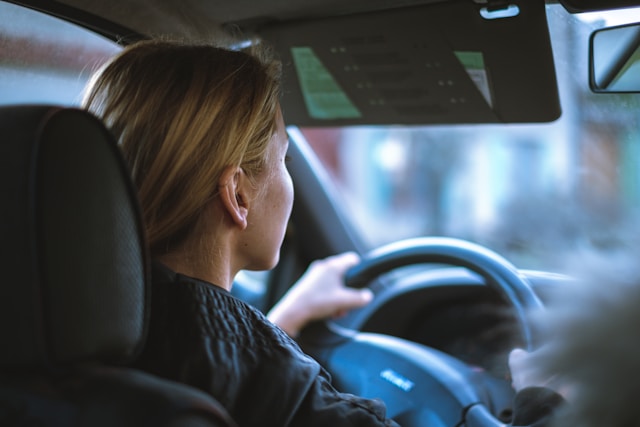 blonde woman in passenger seat driving car