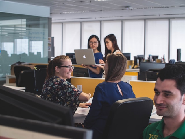 people working on computers at desks in office