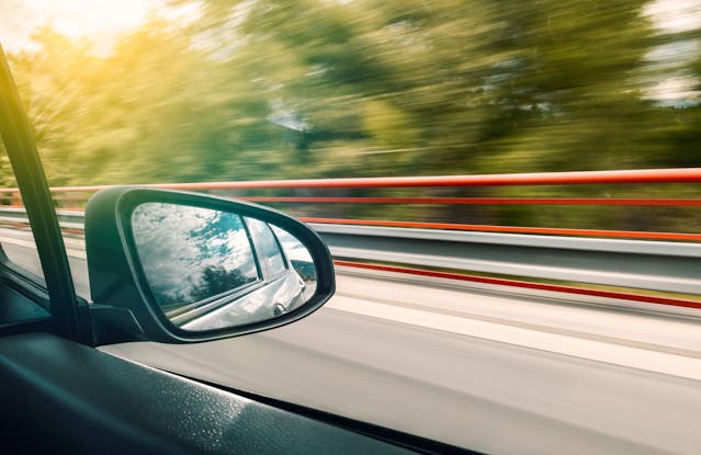 view of side mirror on car traveling fast