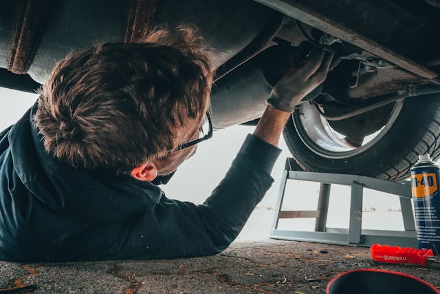 mechanic working on car laying underneath