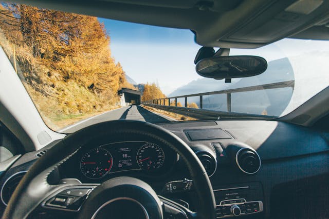 view from driver's seat in car on road heding to tunnel with trees along the road