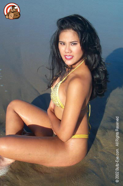 Jazmine in yellow thong bikini sitting on beach