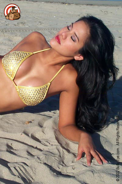 Jazmine in yellow thong bikini laying on beach