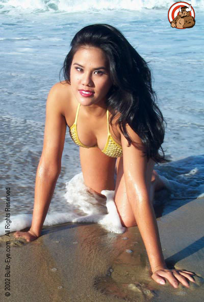 Jazmine in yellow thong bikini crawling on beach with water rolling up