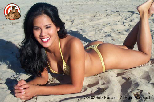Jazmine in yellow thong bikini laying on beach