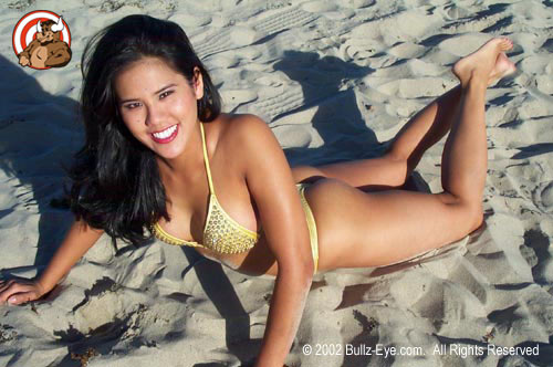 Jazmine in yellow thong bikini laying on beach