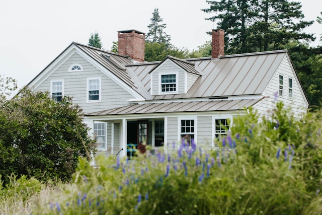 light colored house with greenery in front