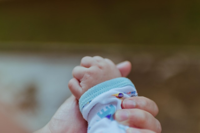 close-up of mother's hand holding baby's hand