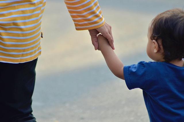 close-up of mother's hand holding hand of young child