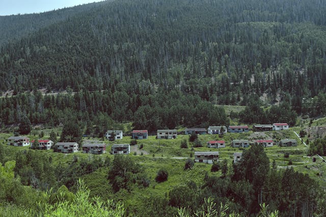 historic ghost town in mountain valley with trees
