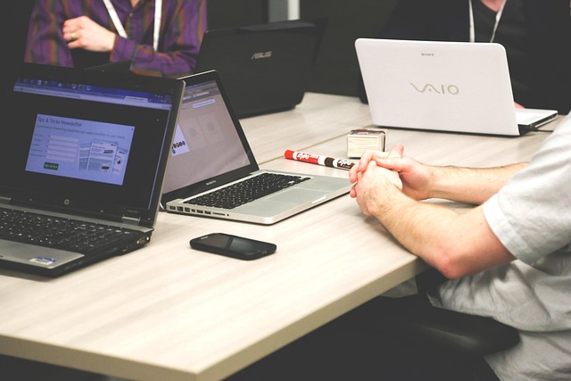workers sitting around table with laptops