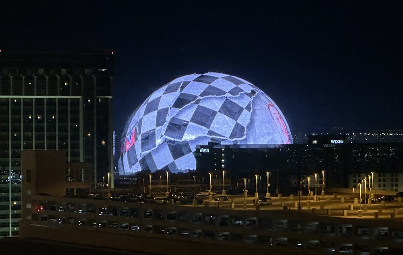 The Sphere at night in Las Vegas checkered flag design view from Planet Hollywood